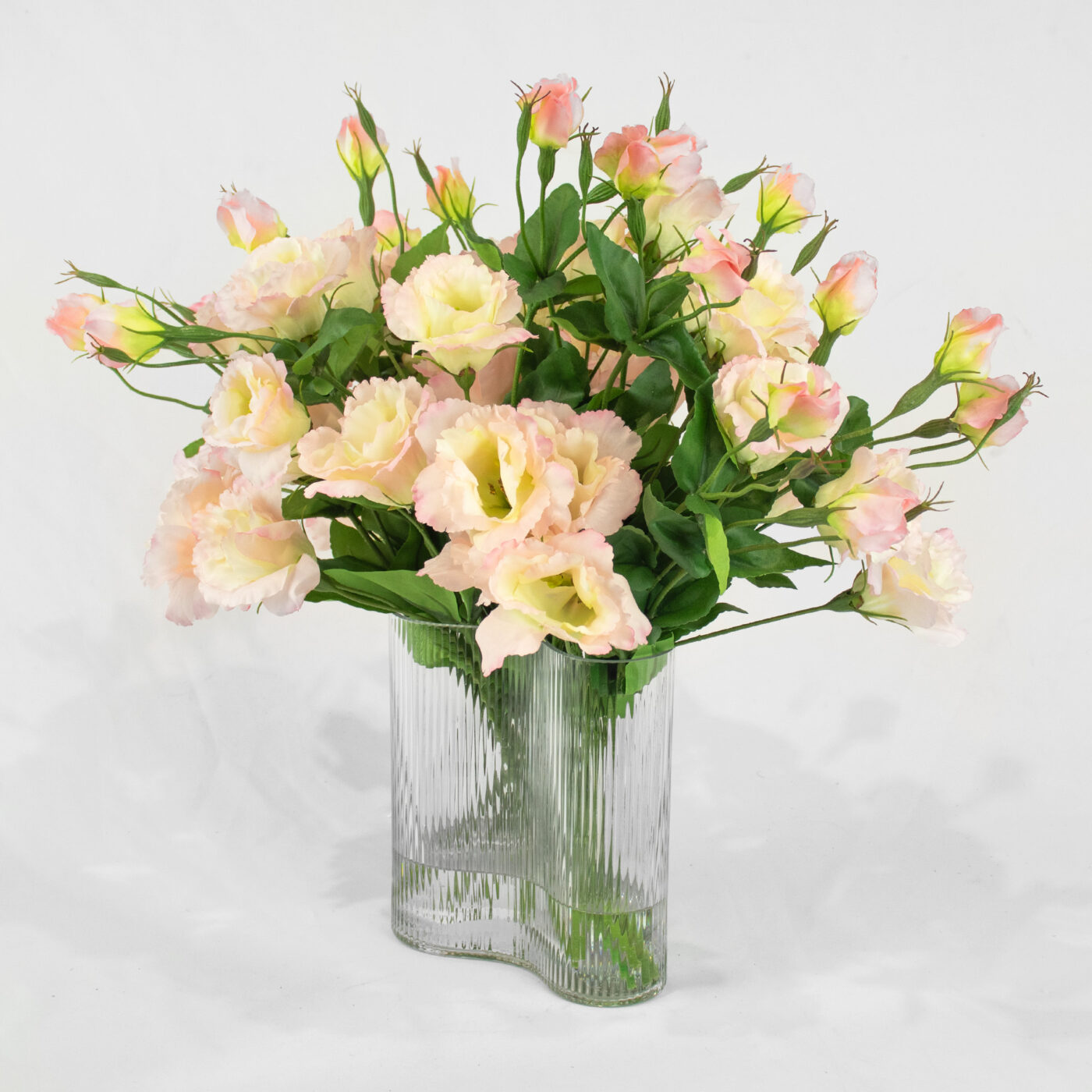 Pink Lavender Lisianthus flower arrangement set in a clear curved ribbed vase