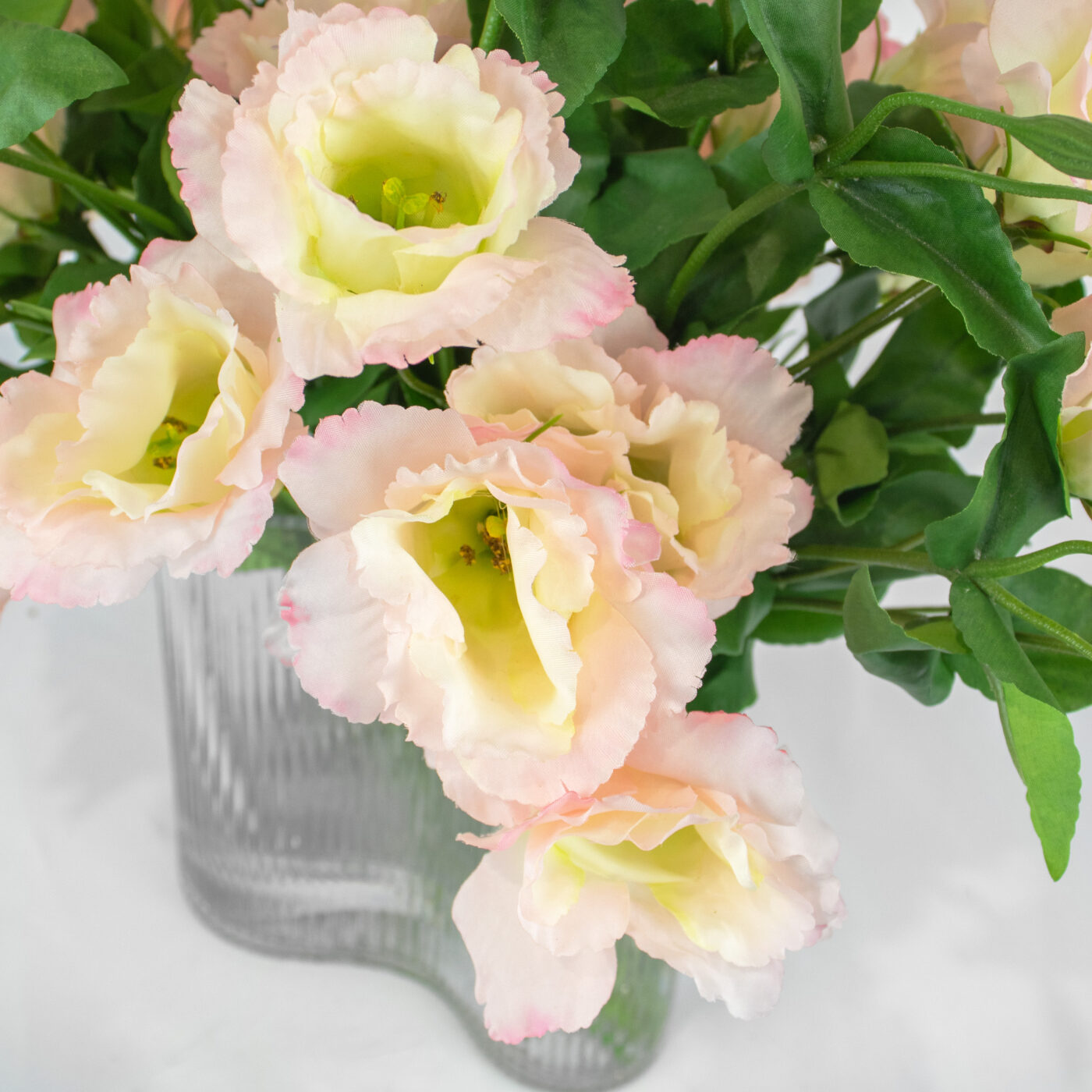 Pink Lavender Lisianthus flower arrangement set in a clear curved ribbed vase