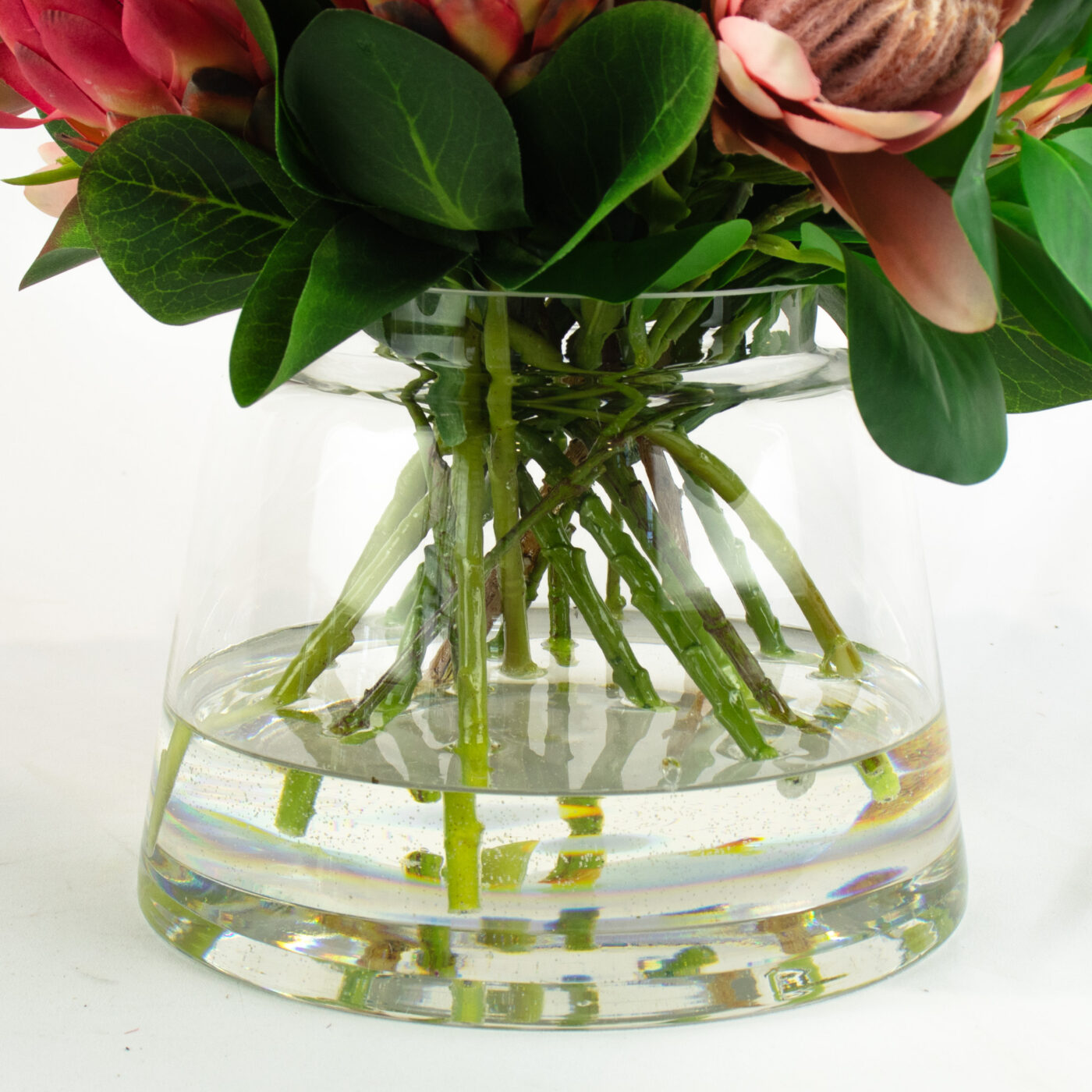 PROTEA MIX WITH FOLIAGE AND TWIG IN GLASS VASE