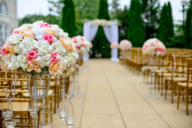 elegant wedding flowers in pink, cream and white roses. decorations down the aisle.