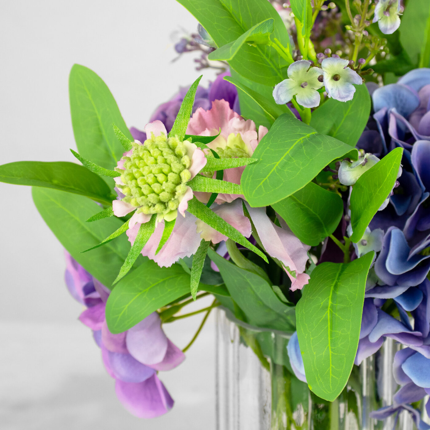 HYDRANGEA BLUE AND PURPLE WITH FOLIAGE IN RIBBED RECT VASE
