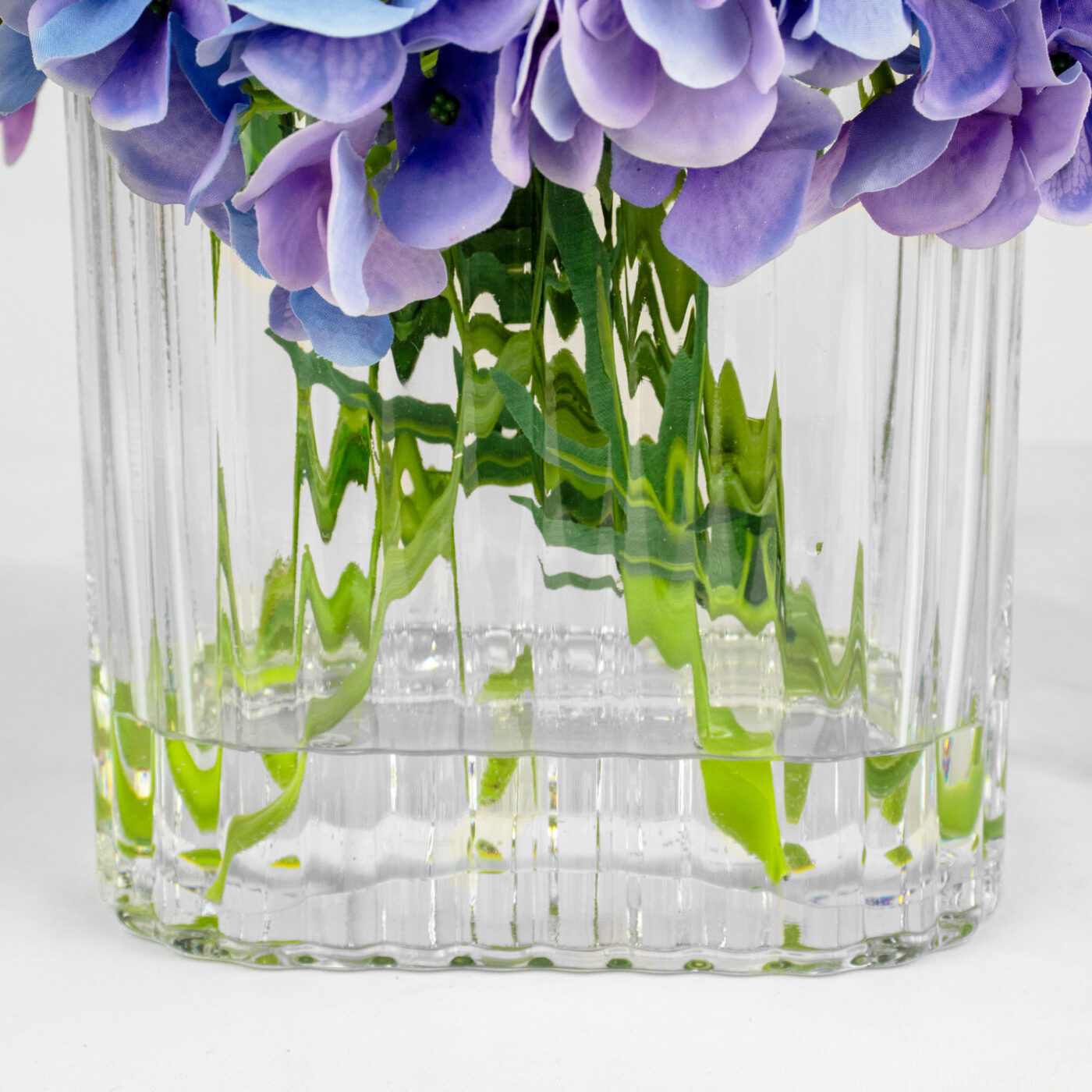 HYDRANGEA BLUE AND PURPLE WITH FOLIAGE IN RIBBED RECT VASE