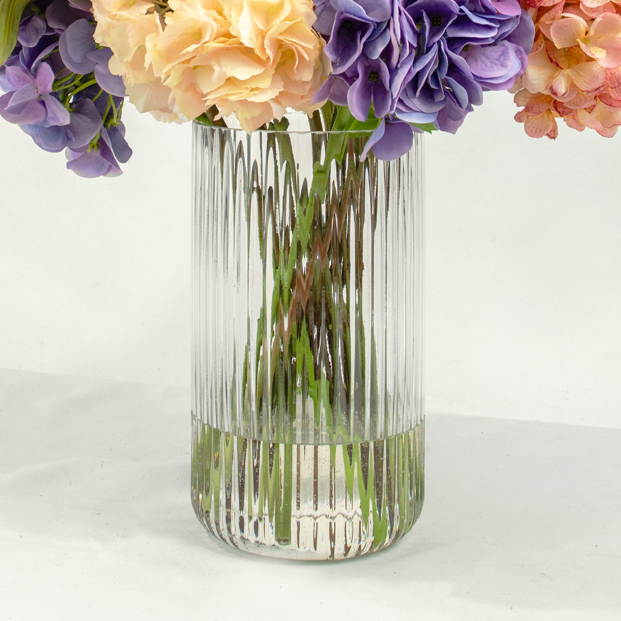 MIXED COLOUR HYDRANGEAS IN RIBBED CYLINDER VASE