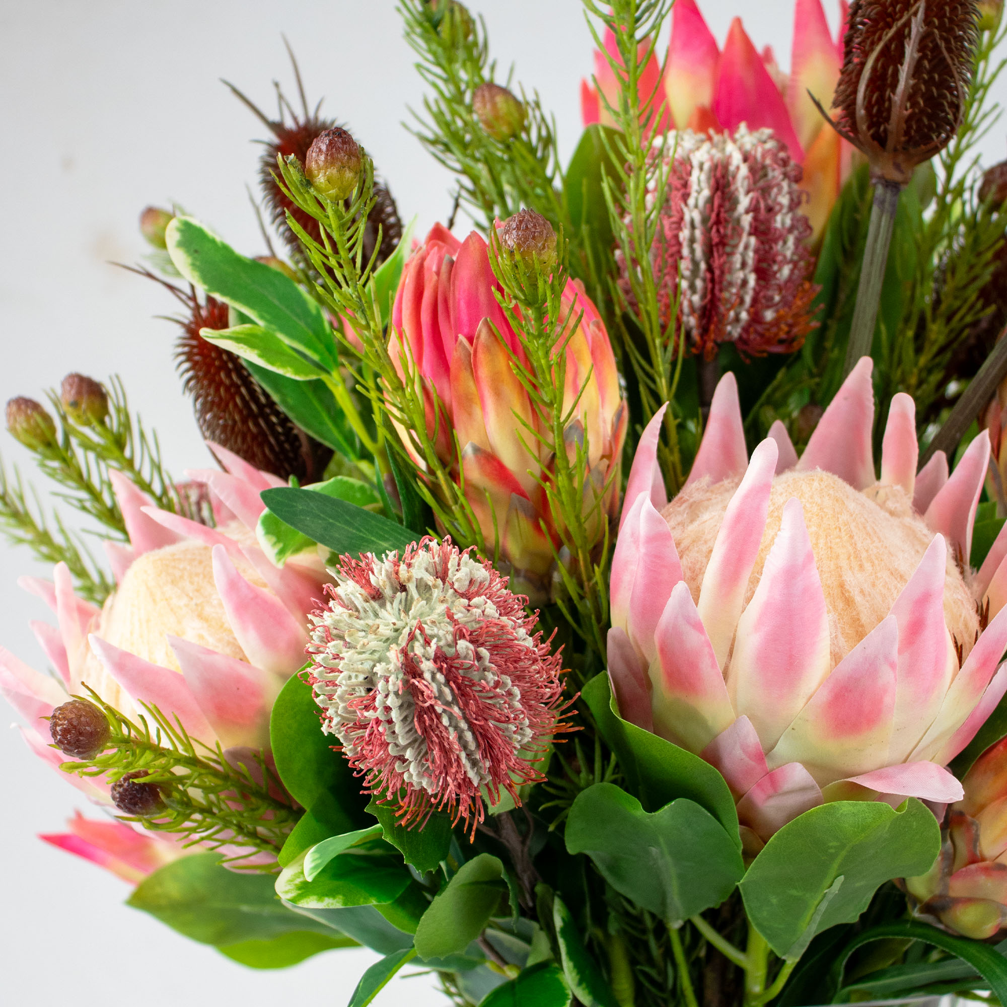 PROTEA MIX WITH PROTEA SPRAY AND FOLIAGE IN CONICAL VASE