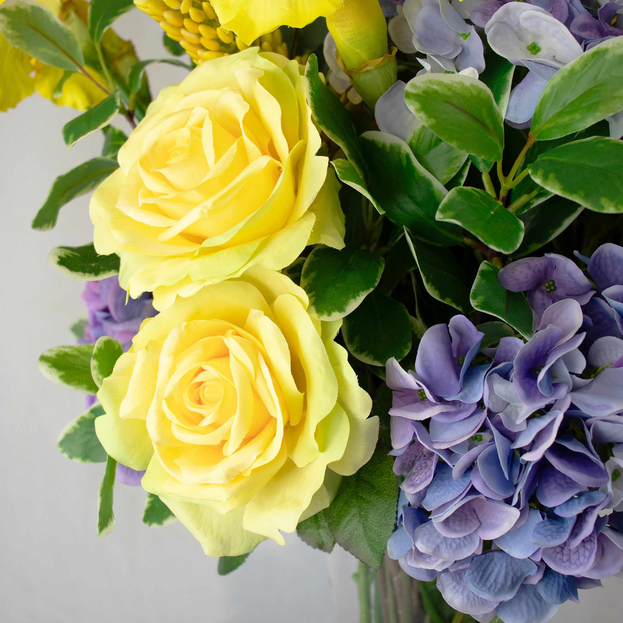 Mixed Yellow And Blue Blooms In Conical Vase