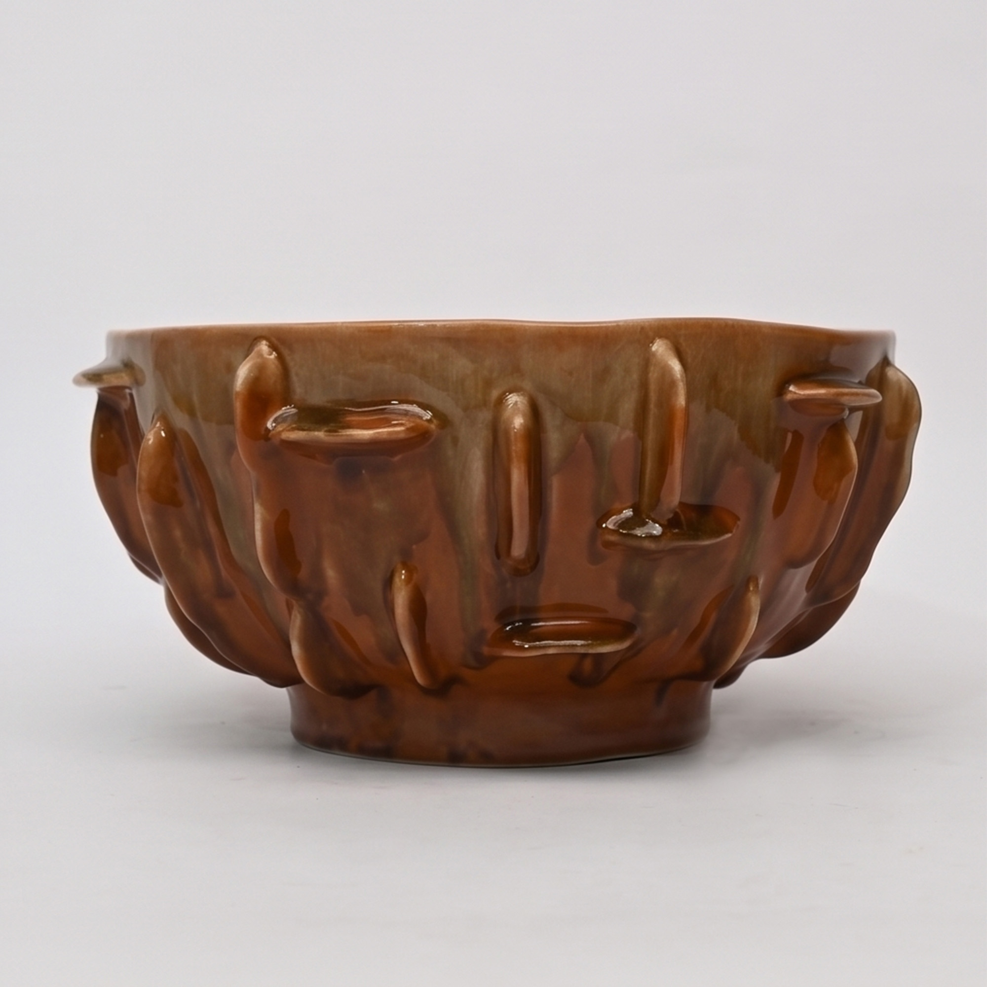 Large 34cm earth drip glaze ceramic bowl with tactile raised ribs sitting on a wide dining table.
