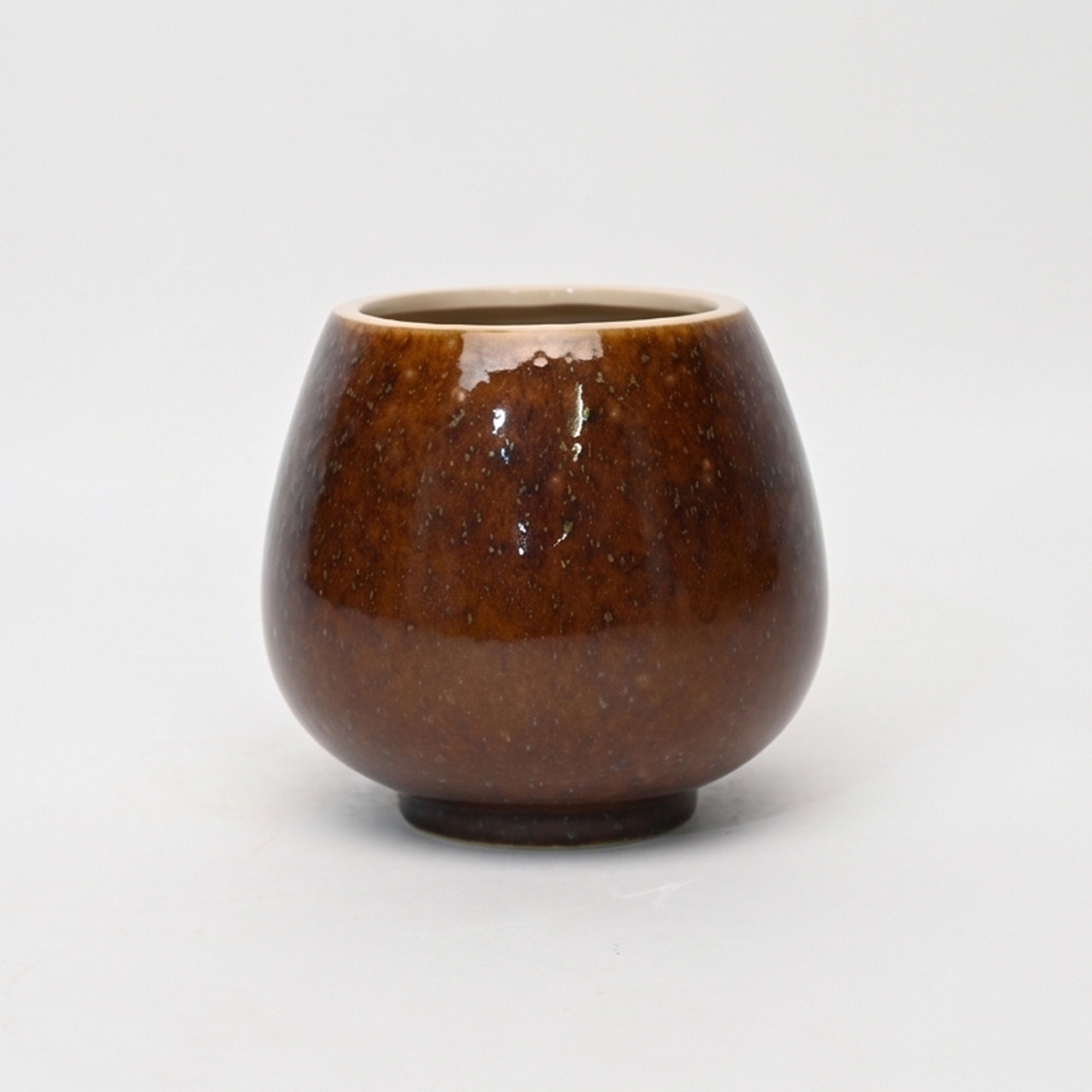 Medium 18cm toffee speckled ceramic bellied pot with a tactile glazed finish styled on a wooden dining table.
