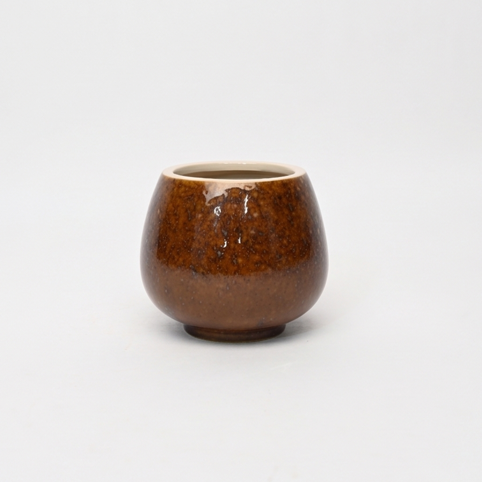 Small 15.7cm toffee speckled ceramic bellied pot with a tactile glazed finish sitting on a bedside table.
