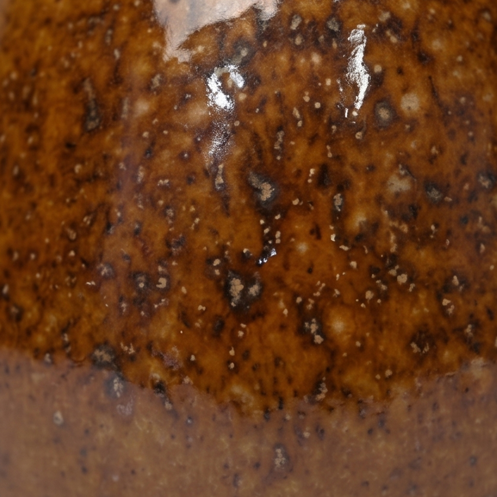 Small 15.7cm toffee speckled ceramic bellied pot with a tactile glazed finish sitting on a bedside table.