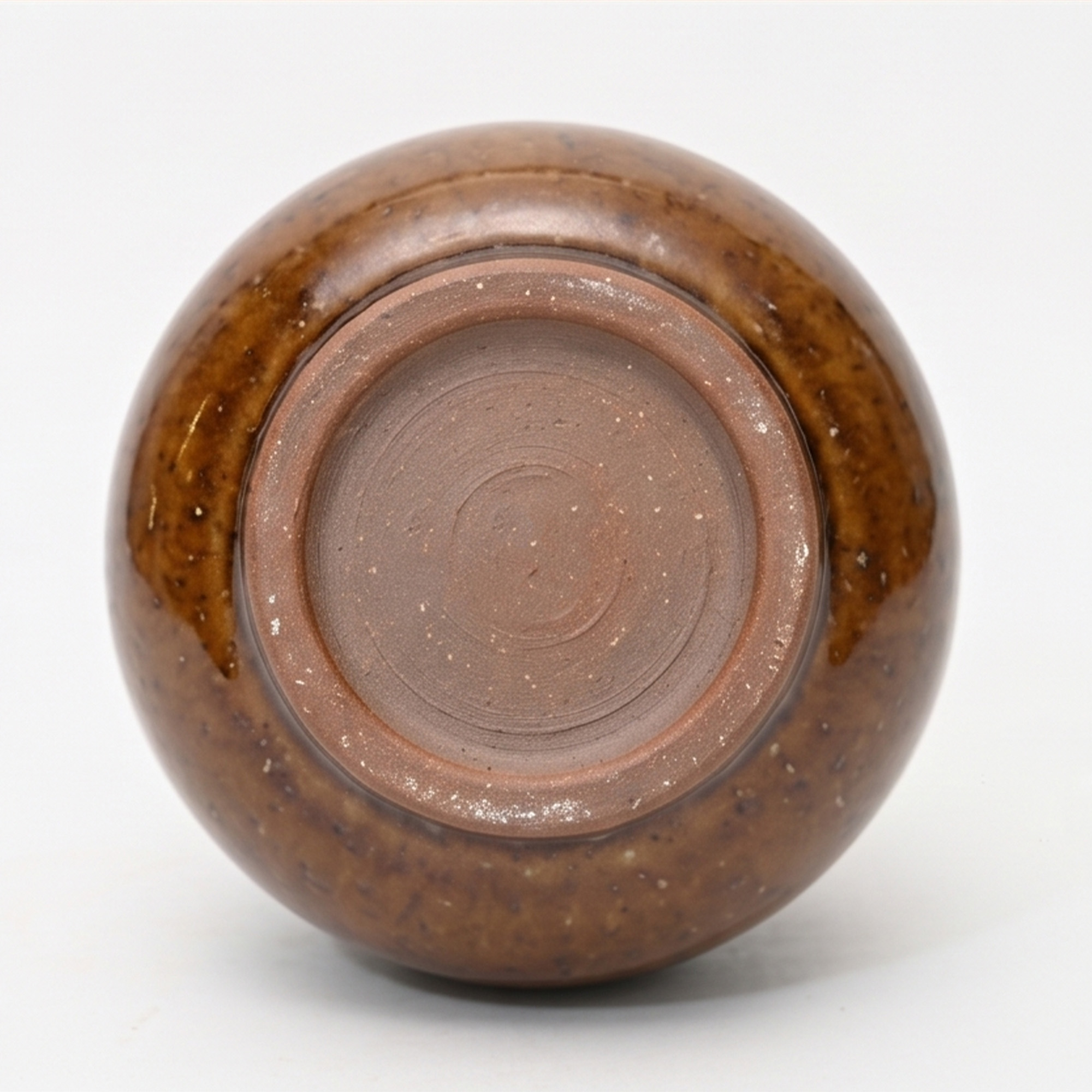 Small 15.7cm toffee speckled ceramic bellied pot with a tactile glazed finish sitting on a bedside table.