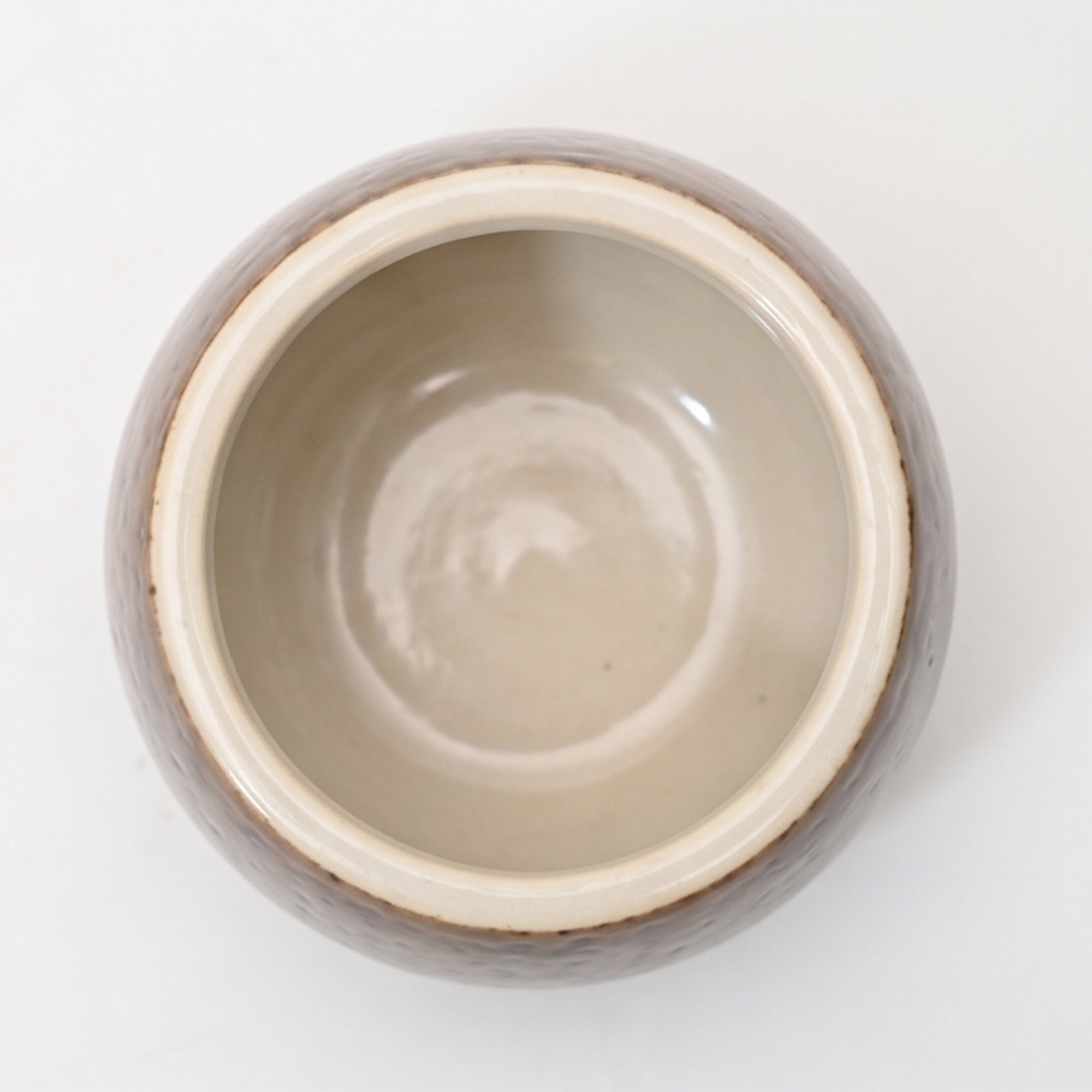 Small 15.7cm toffee speckled ceramic bellied pot with a tactile glazed finish sitting on a bedside table.