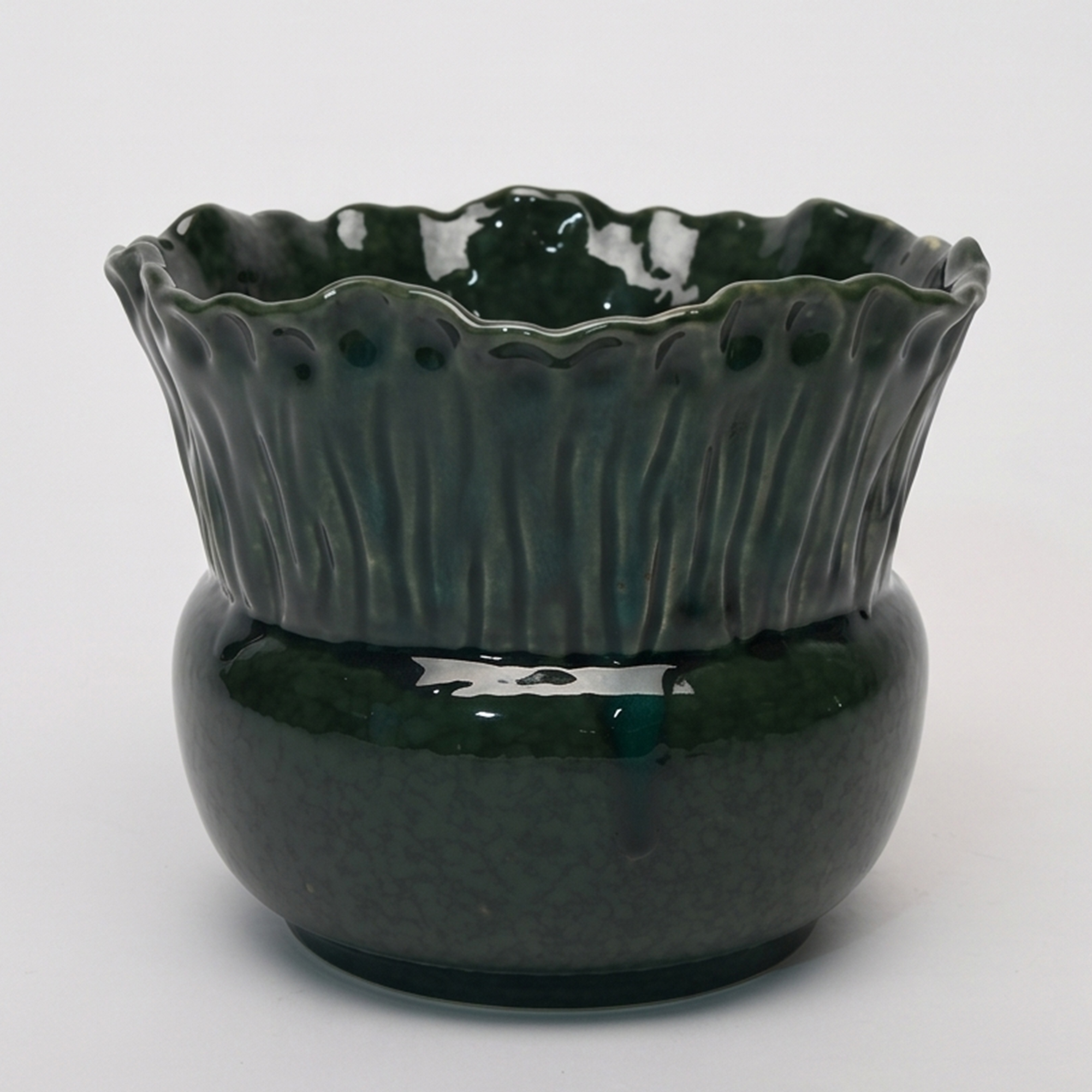 Medium 21.5cm emerald green scalloped ceramic bulbous pot with a fluted rim styled on a wooden entryway console.