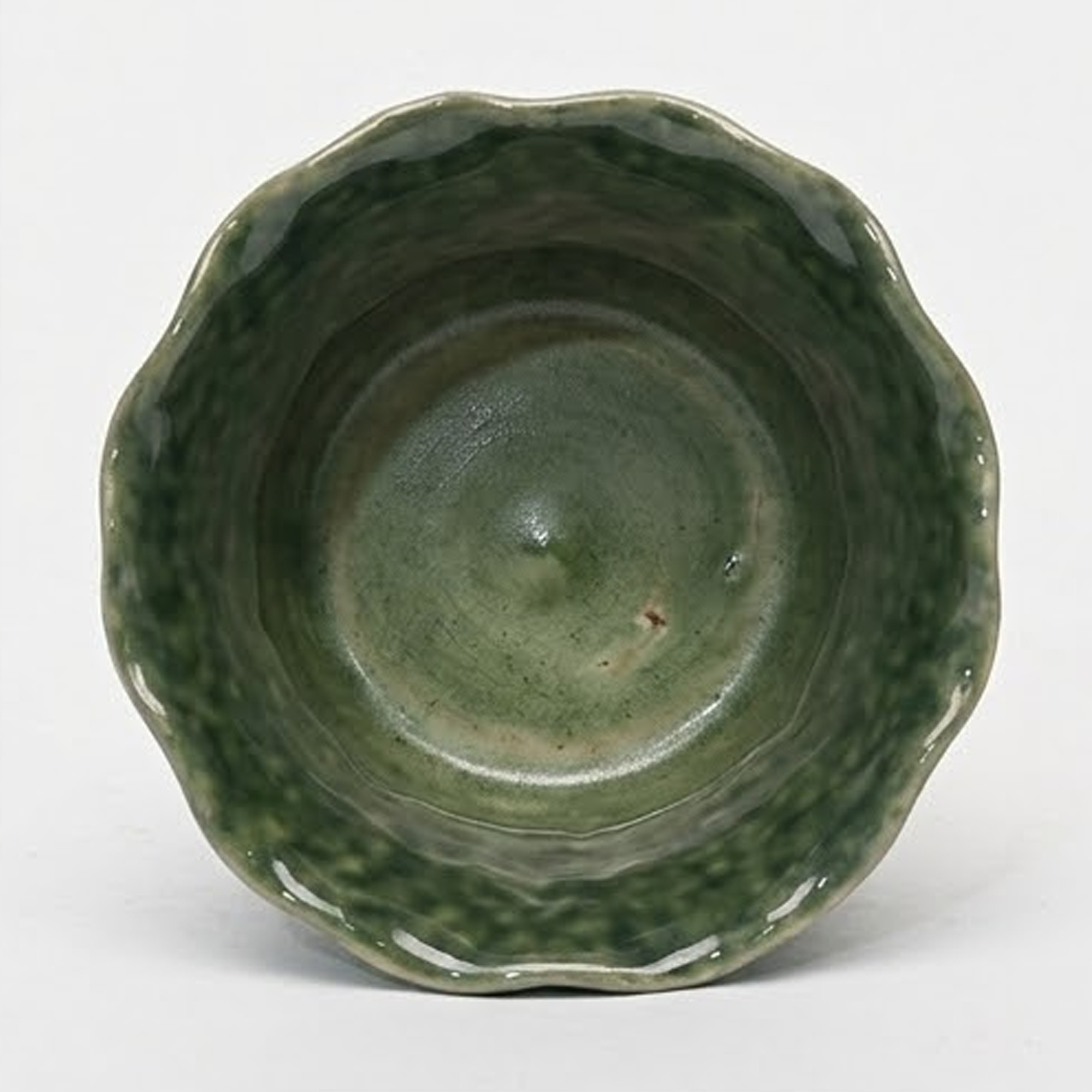 Extra small 11.4cm emerald green scalloped ceramic bulbous pot with a fluted rim styled on a wooden entryway console.