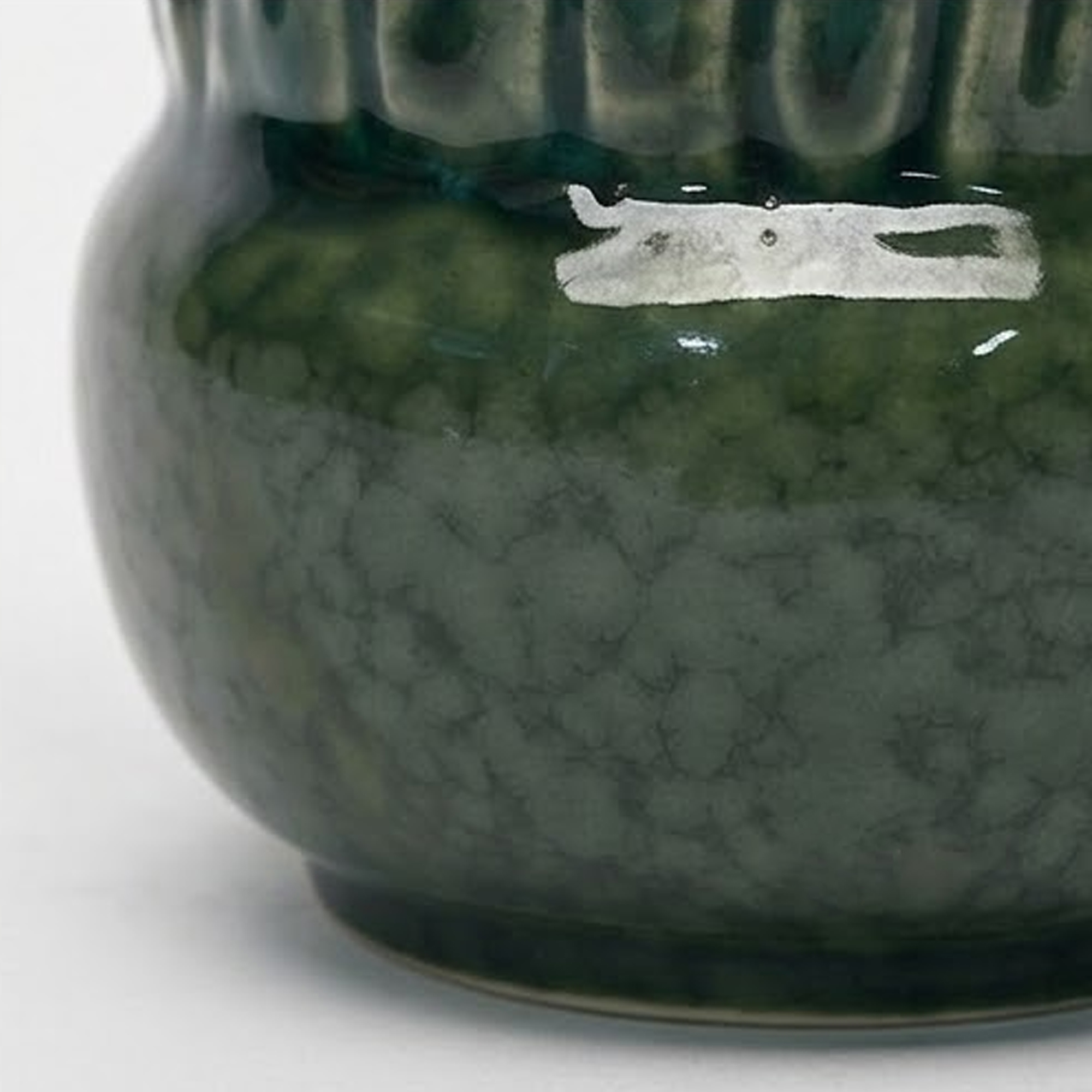 Extra small 11.4cm emerald green scalloped ceramic bulbous pot with a fluted rim styled on a wooden entryway console.