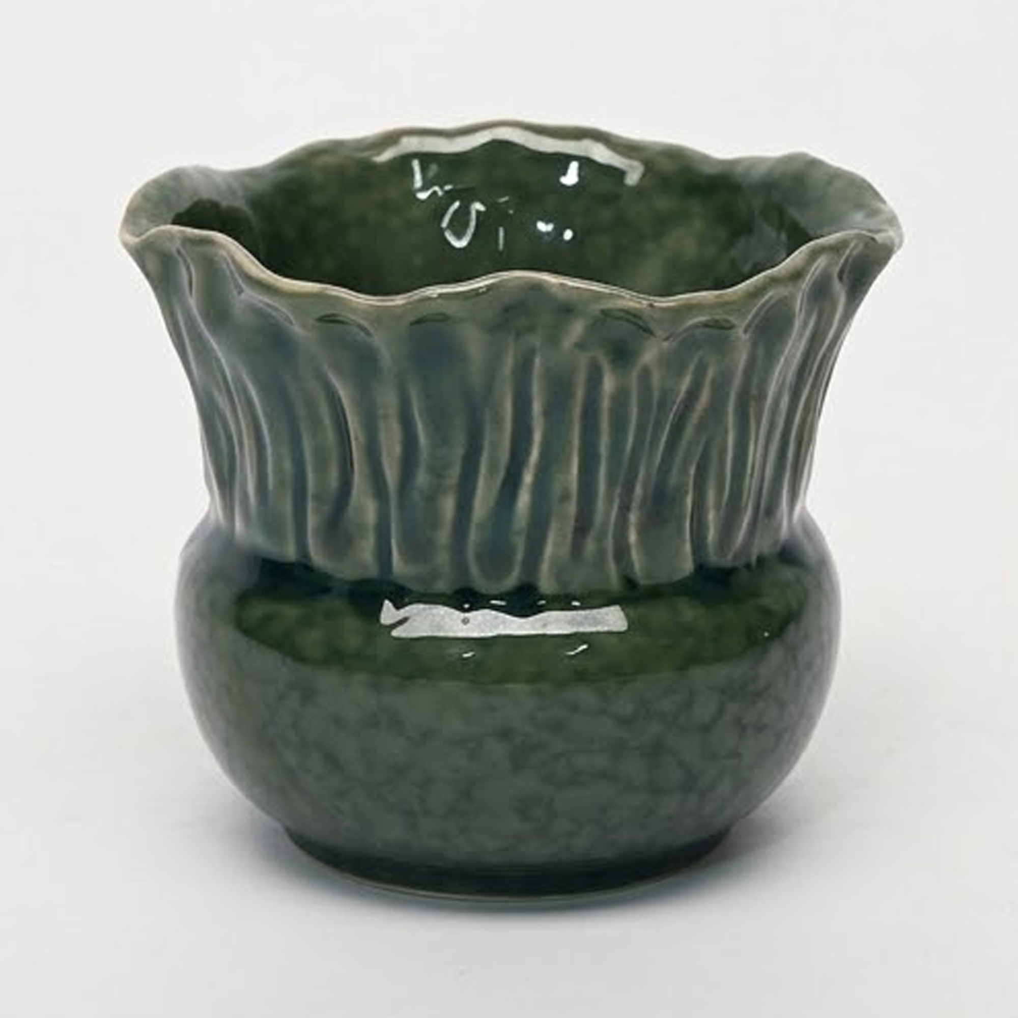 Extra small 11.4cm emerald green scalloped ceramic bulbous pot with a fluted rim styled on a wooden entryway console.
