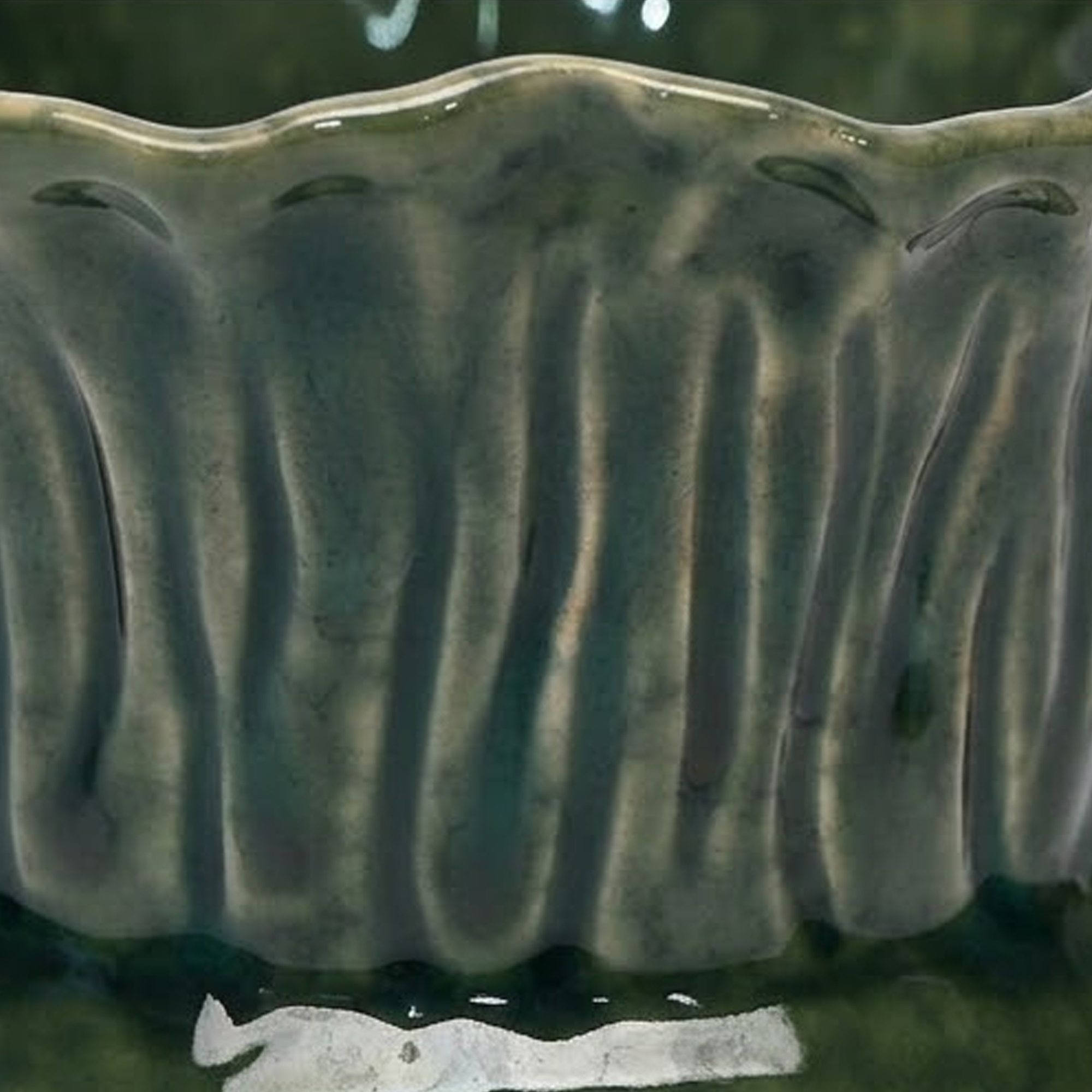 Extra small 11.4cm emerald green scalloped ceramic bulbous pot with a fluted rim styled on a wooden entryway console.
