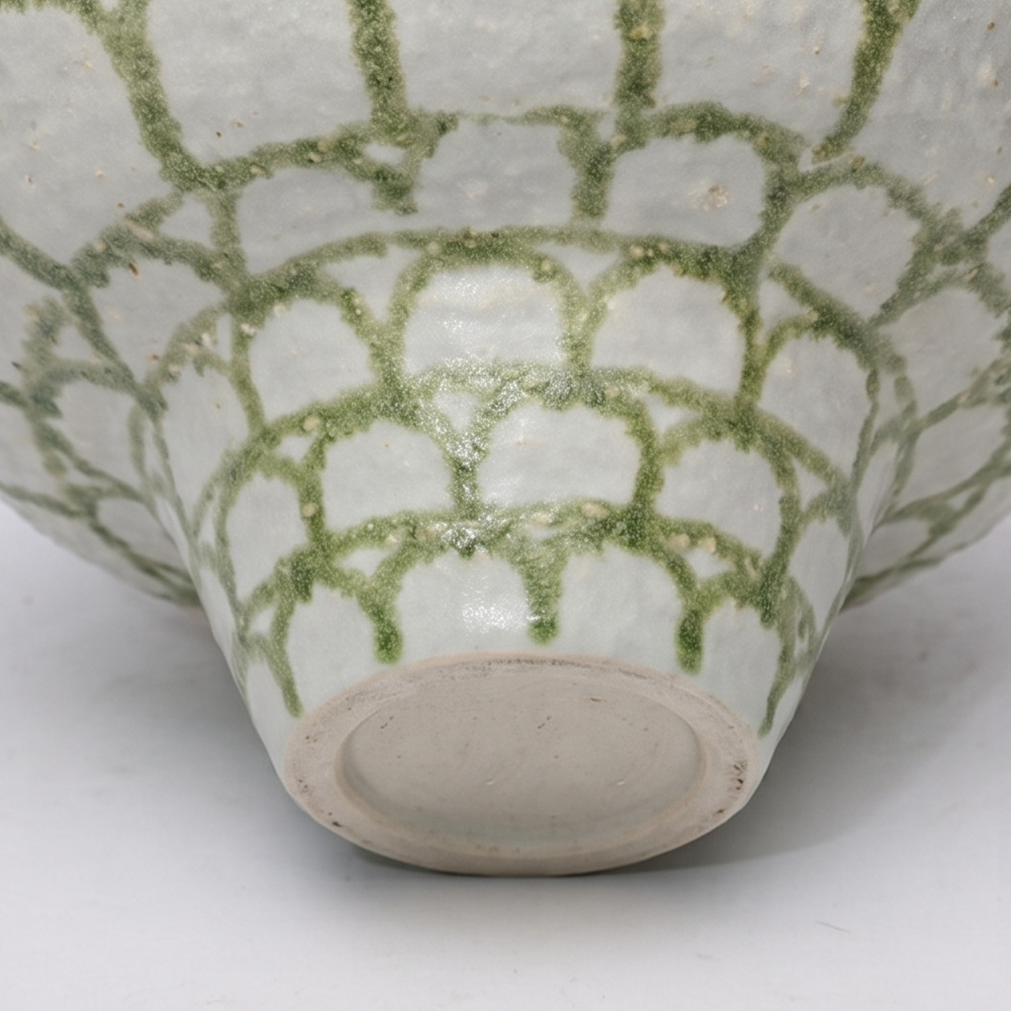 Extra large 31.5cm matte arch pattern green and white ceramic pedestal bowl styled on a wooden dining room sideboard.