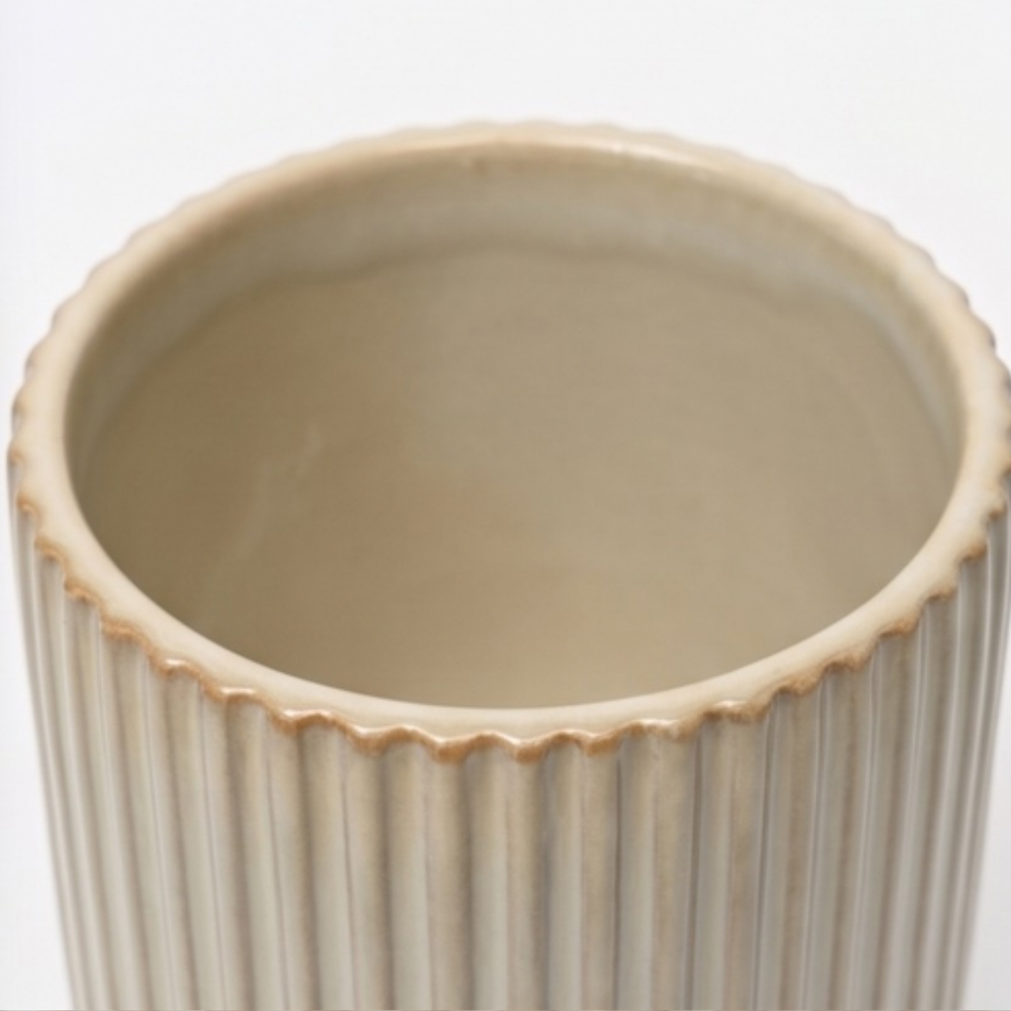 Small 14cm ribbed cream ceramic planter with a rounded base and vertical ribbing styled on a wooden dining room sideboard.