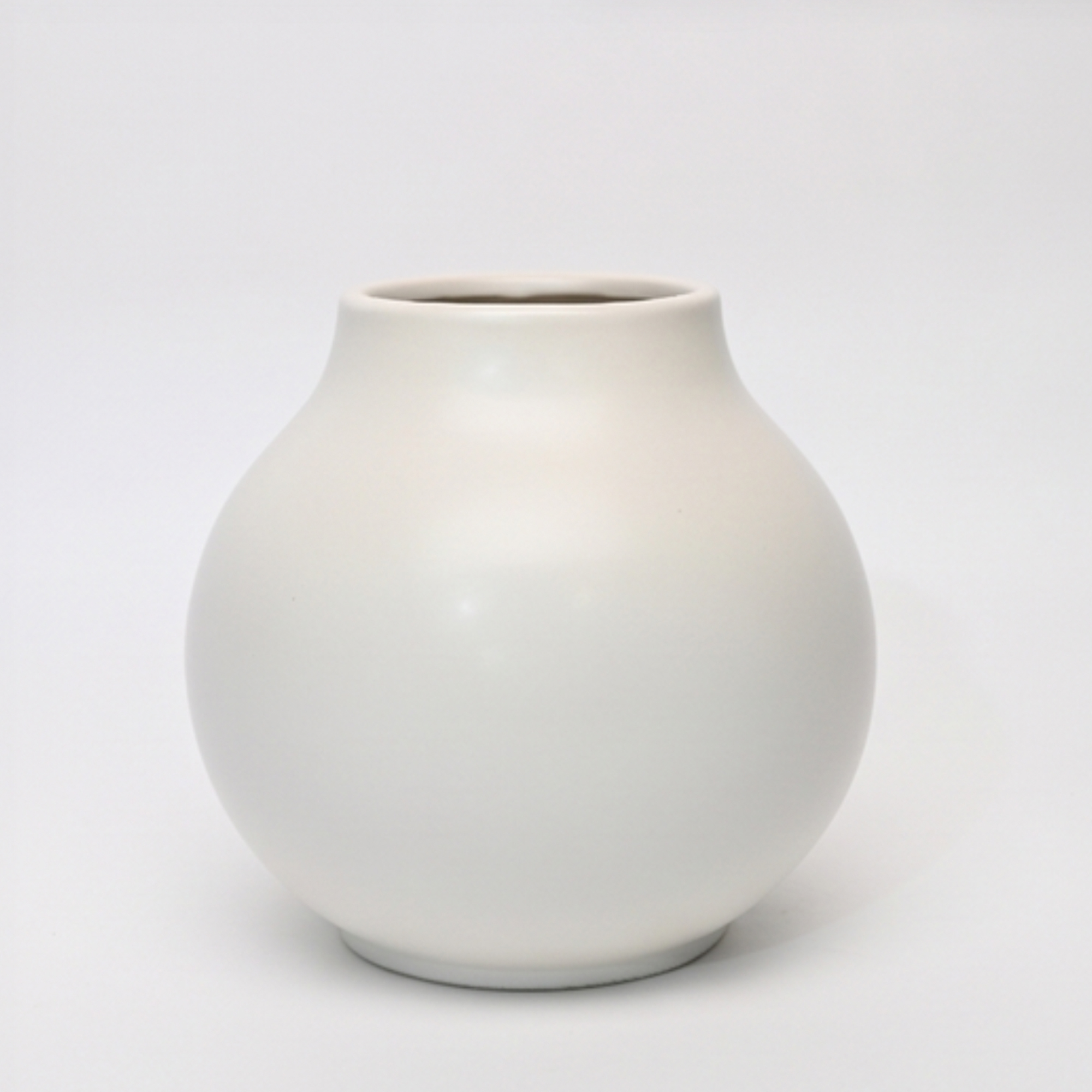 Large 24.5cm classic white ceramic ball vase with a smooth matte finish styled on a wooden dining room sideboard.