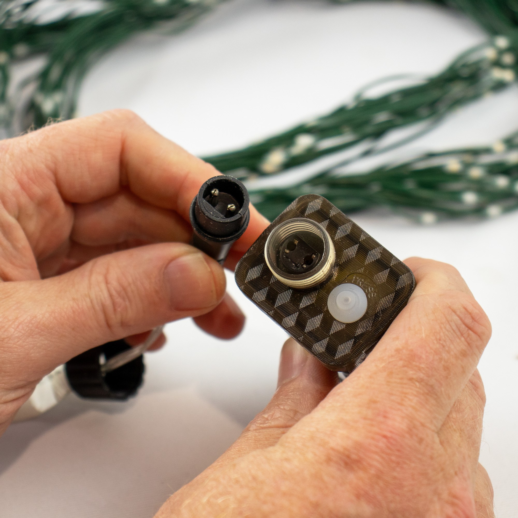 600 warm white LED Christmas tree curtain lights on a green cord with a remote control and power adapter.